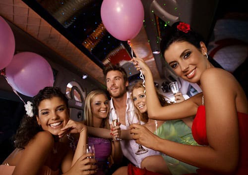 Party Limousine Group having a party with balloons and drinks in the back of a limo